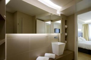 a bathroom with a shower with a mirror and a bed at O&B Athens Boutique Hotel in Athens