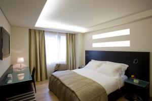 - une chambre avec un grand lit et une fenêtre dans l'établissement O&B Athens Boutique Hotel, à Athènes