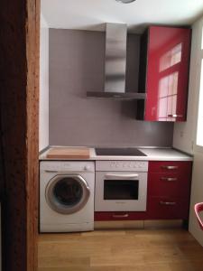 a kitchen with a stove and a washing machine at Grand Plaza Mio Cid in Burgos