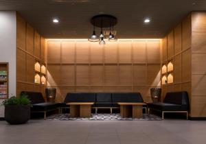 a waiting area with couches and tables in a lobby at Nishitetsu Inn Shinjuku in Tokyo