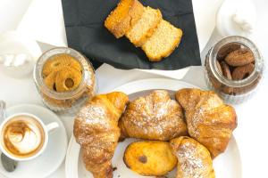 a plate of pastries on a table with a cup of coffee at Hotel Miramare in Otranto