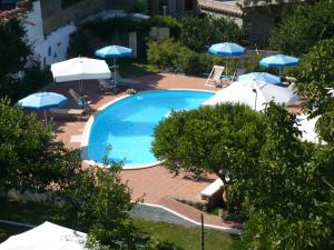 una gran piscina con sombrillas y sillas en Hotel Savoia en Procida