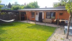 Cette maison dispose d'une terrasse et d'une pelouse. dans l'établissement FERIENBUNGALOW Schwanck in Sagard, à Sagard