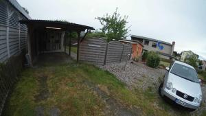 a white car parked in front of a garage at FERIENBUNGALOW Schwanck in Sagard in Sagard +20 photos