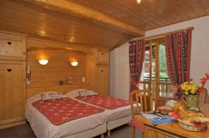 a bedroom with a bed and a table in a room at L'Hermine Blanche in Morzine