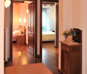 Habitación con dormitorio con cama y espejo. en Agriturismo Fogolar da Capo, en Orzano