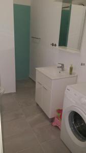 a bathroom with a washing machine and a sink at Family House Nerezine in Nerezine