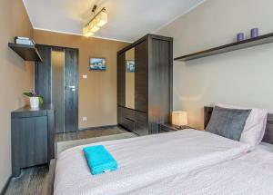 Un dormitorio con una cama grande con una toalla azul. en Mieszkanie Classa - ACCO RENT en Gdansk