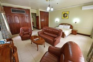 a living room with a couch and a bed at Grand Imperial Hotel in Kampala