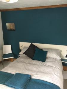 a bedroom with a bed with a blue wall at Erin Cottage in Derry Londonderry