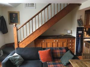 ein Wohnzimmer mit einer Couch und einer Treppe in der Unterkunft Erin Cottage in Derry Londonderry
