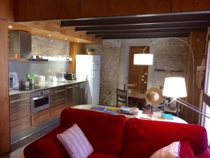 sala de estar con sofá rojo y cocina en Niu, en Saldet