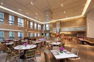 a restaurant with tables and chairs in a room at Ramada Jinan in Jinan