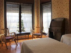 a bedroom with two beds and a piano and windows at Hostal Rita Belvedere in Puigcerdà