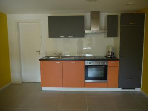 una cucina con forno arancione e nero di Studio im Haus in Seenähe a Reinfeld