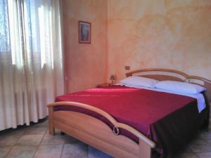 ベヴァーニャにあるAgriturismo "Vecchia Fattoria"のベッドルーム1室(赤毛布付きの大型ベッド1台付)