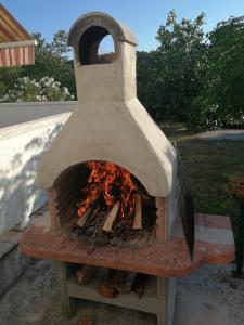 a pizza oven with a fire inside of it at Apartment Tea in Rab