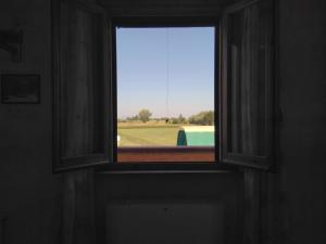 ベヴァーニャにあるAgriturismo "Vecchia Fattoria"の野原の景色を望む部屋の窓