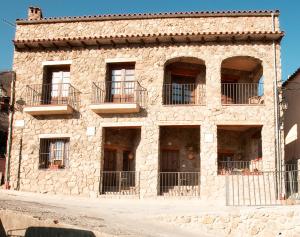 un edificio de piedra con balcones en un lateral en Casa Rural Puria, en Rebollar