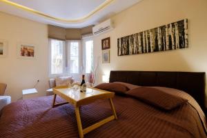ein Schlafzimmer mit einem Bett und einem Tisch mit einer Flasche Wein in der Unterkunft Enjoy Belgrade in Belgrad
