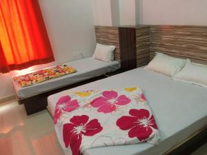 ein Schlafzimmer mit 2 Betten mit Blumen drauf in der Unterkunft Hotel Thikana Palace in Jaipur