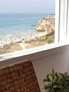 a room with a view of the beach from a window at Marisol Apt Algarve in Armação de Pêra