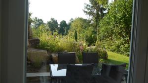 un patio con tavolo e sedie e un giardino di Studio im Haus in Seenähe a Reinfeld