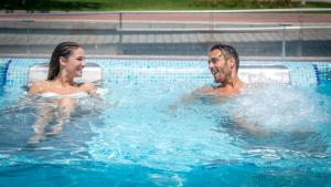a man and a woman in a swimming pool at RH Bayren Hotel & Spa 4* Sup in Gandía