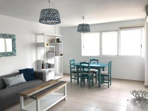 a living room with a couch and a table and chairs at La Marinera 37 in Cotillo