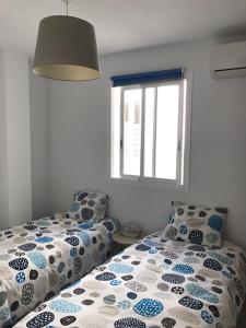 コティージョにあるLa Marinera 37のベッド2台と窓のある寝室