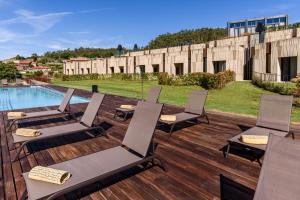 a patio with lounge chairs and a swimming pool at Pousada Armenteira in Pontevedra