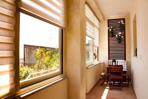 a hallway with a window and a table and chairs at Taormina Family Apartment in Taormina