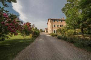 un camino vacío delante de un edificio en Agriturismo Il Brugnolo, en Scandiano