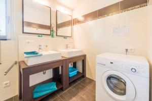 a bathroom with a washing machine and a washer and dryer at Almliesl MAIS-428 in Maishofen
