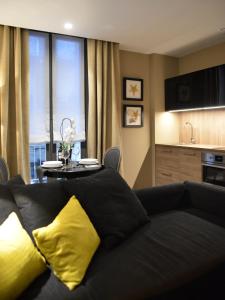 un divano nero con cuscini gialli in soggiorno di QB/four a Catania