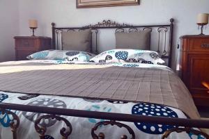 - un lit avec un cadre en métal et des oreillers dans l'établissement Agriturismo Verdure Naturali, à Gênes