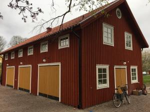 um celeiro vermelho com uma bicicleta estacionada em frente dele em Forsa Gård Attic em Katrineholm