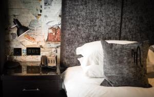 ein Schlafzimmer mit einem Bett, einem Kissen und einem Telefon in der Unterkunft Malmaison Reading in Reading