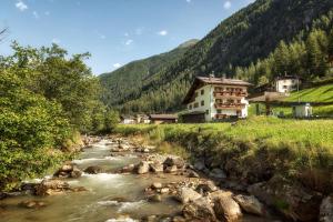 une rivière dans une vallée avec des maisons et une montagne dans l'établissement B&B Cicolini, à Rabbi