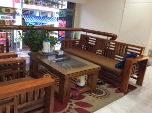 a bench in a room with a table and chairs at Hoang Oanh Hotel in Quy Nhon