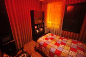 1 dormitorio con 1 cama con una manta colorida en Apartment Urushadze, en Batumi
