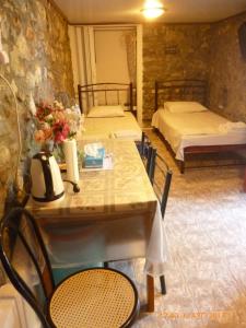 a table and chairs with two beds in a room at Kalapo Apartment in Tseratsiá