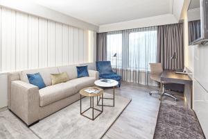 a living room with a couch and a table at Clayton Hotel Düsseldorf City Centre in Düsseldorf