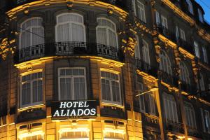 um grande edifício com um sinal de hotel alldos em Hotel Aliados em Porto