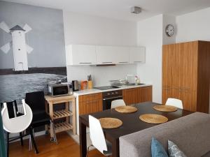 a kitchen with a table and a kitchen with a lighthouse at AGAT Apartamenty in Świnoujście