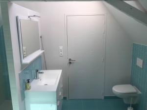 a bathroom with a toilet and a sink and a shower at La Récré in Restigné