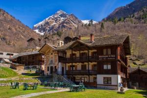 a building with a mountain in the background at Albergo Montagna Di Luce in Alagna Valsesia