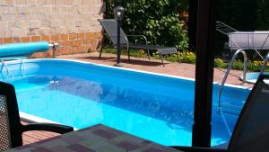 a swimming pool with a chair next to a brick wall at Pension Tip-Top in Târgu-Mureş