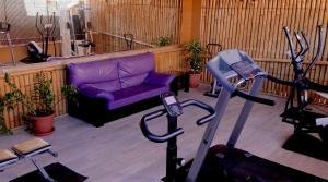 sala de estar con sofá púrpura y gimnasio en Bungalows Los Almendros - Exclusive Vacation Club, en Playa del Inglés