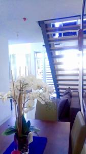 een woonkamer met een bank en een tafel met bloemen bij Affordable Makati APT in Manilla